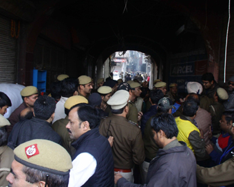 New Delhi: Onlookers with police personnel at the area of a fire incident in which 43 people died in West Delhi