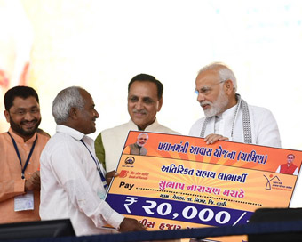 Valsad: Prime Minister Narendra Modi felicitates beneficiaries of various development schemes during a public meeting in Valsad, Gujarat.