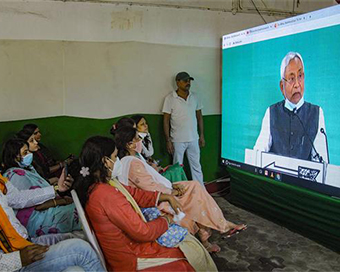 Supporters watch Bihar CM Nitish Kumar address on a screen during virtual rally in Patna