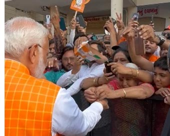 Woman ties rakhi to PM Modi as huge crowd gathers outside polling booth in Ahmedabad